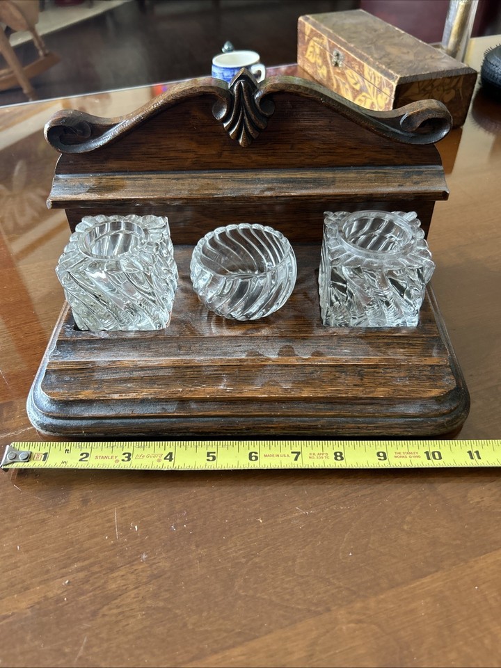 A trio of swirled block-glass inkwells on a wooden base — mid-century desk sculpture that looks like it belongs in a design museum.