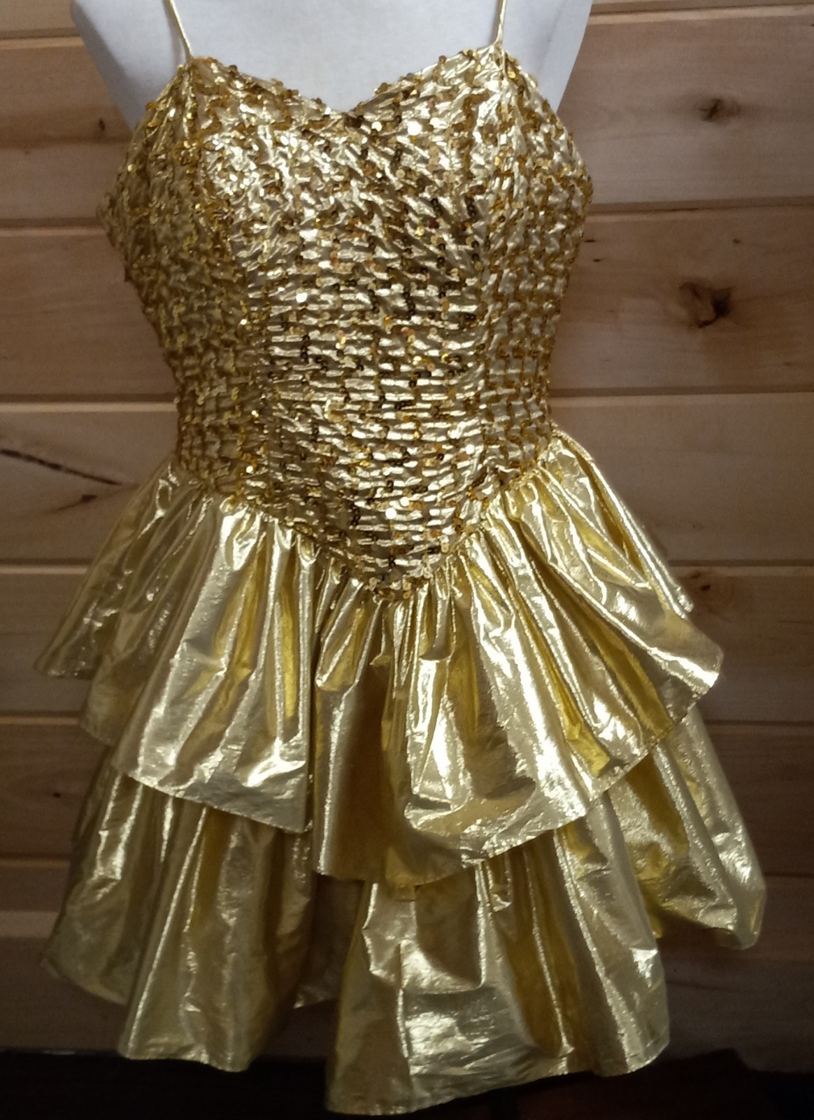 Gold lamé spaghetti-strap party dress on a hanger