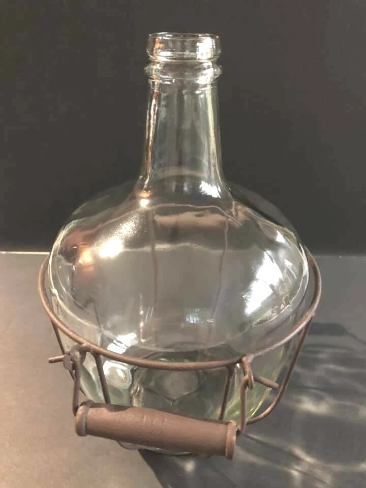 Botella gruesa de vidrio transparente con asa de estante de metal rústico Foto 2 de 4