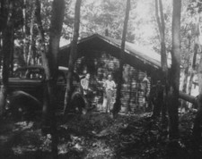 Hombres guapos por cabaña y coche de colección aventura rústica años 30 camping viaje madera