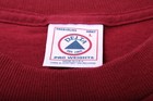 Red vintage 1990s shirt with white embroidered Delta logo, “Made in U.S.A.” text, and care instructions on label.