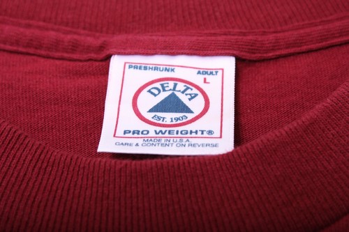 Red vintage 1990s shirt with white embroidered Delta logo, “Made in U.S.A.” text, and care instructions on label.