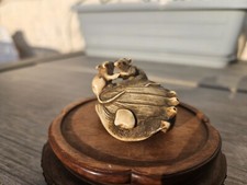 An antique netsuke depicting 2 small mice are dancing on the Abalone shell