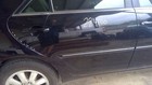 Black side door of 2002-2006 Camry with white handwritten text “224100” and “white” wheels.