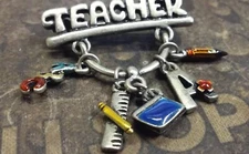 Teacher pin badge with several charms
