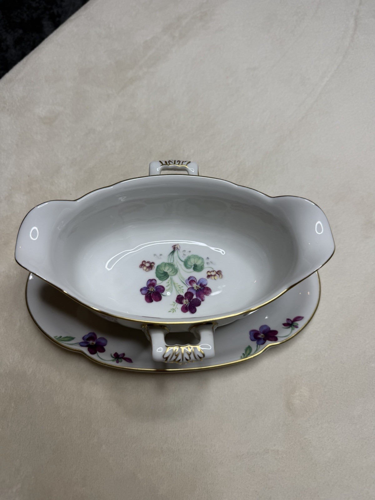 Porcelain gravy boat with attached undertray, hand-painted violet floral motif, marked Royal Bayreuth.