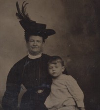 PORTRAIT OF SMIRKING WOMAN IN LARGE FEATHER HAT W/ BOY