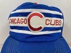 Blue snapback trucker hat with white and red stripe bands and embroidered “Chicago Cubs” text in red lettering.