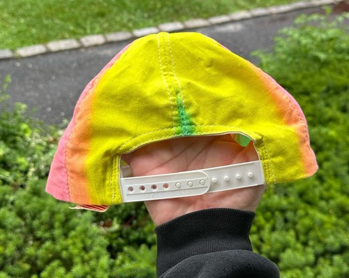 Yellow and orange Panama Jack snapback hat with black fabric, white plastic buckle, and green logo patch on front.