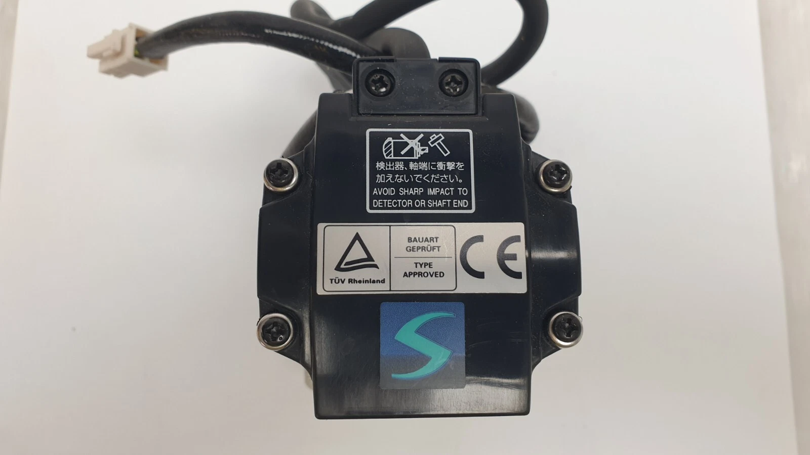 Rear encoder cover of the HC-KFS23K with avoid-sharp-impact warning, TÜV and CE labels