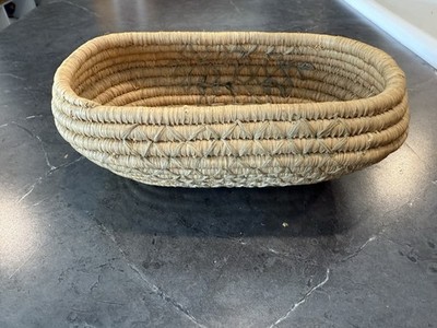 Hand-woven Native American coiled basket made from natural fibers.