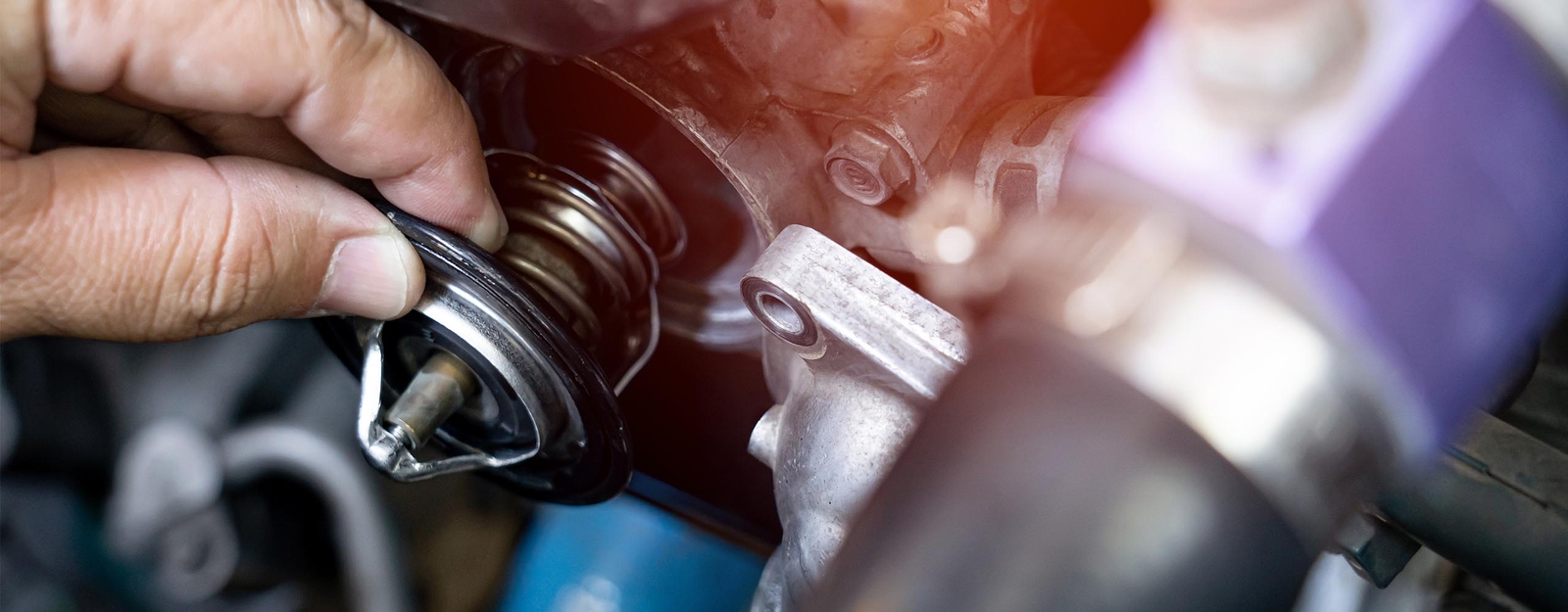 Eine Person kontrolliert, ob das Thermostat im Auto richtig funktioniert.