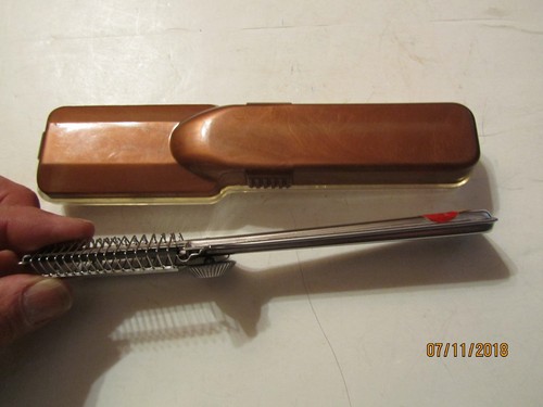 Brown vintage Playtex hair cutter with black handle in clear case, resting on white surface, text “07/11/2018” at bottom.