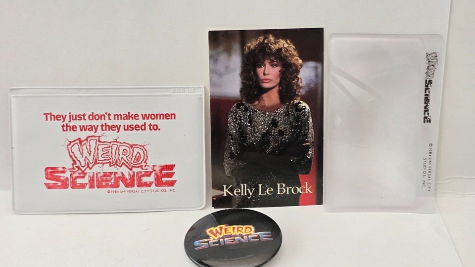 An original 1984 Weird Science promo lot with a Kelly LeBrock card and pin — rare studio ephemera from a genuine 80s cult classic.