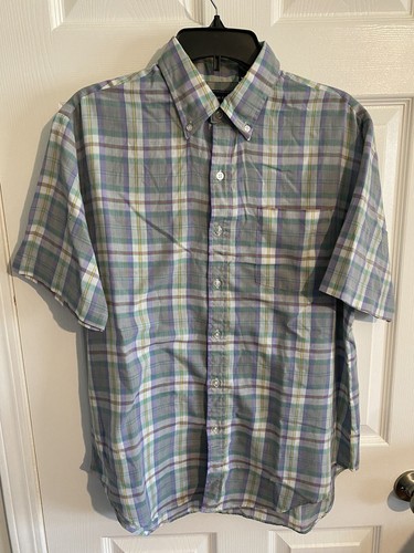 Men’s long-sleeve button-up shirt with green, blue, and yellow plaid pattern and chest pocket, hanging on black hanger.