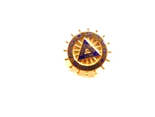 small wheel shaped pin captioned "COSMO PALS" with triangle emblem in center