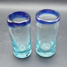 2 hand-blown Mexican shot glasses featuring c...