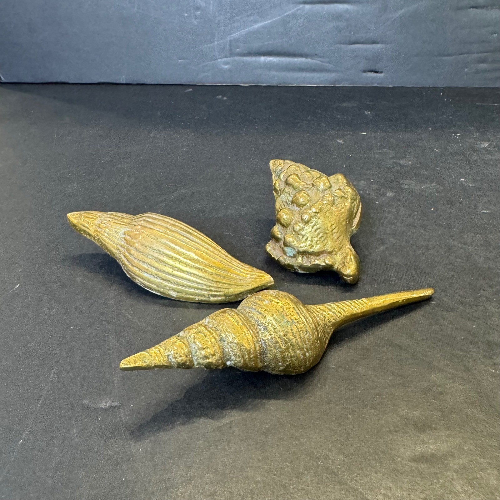Three solid brass seashell figurine paperweights