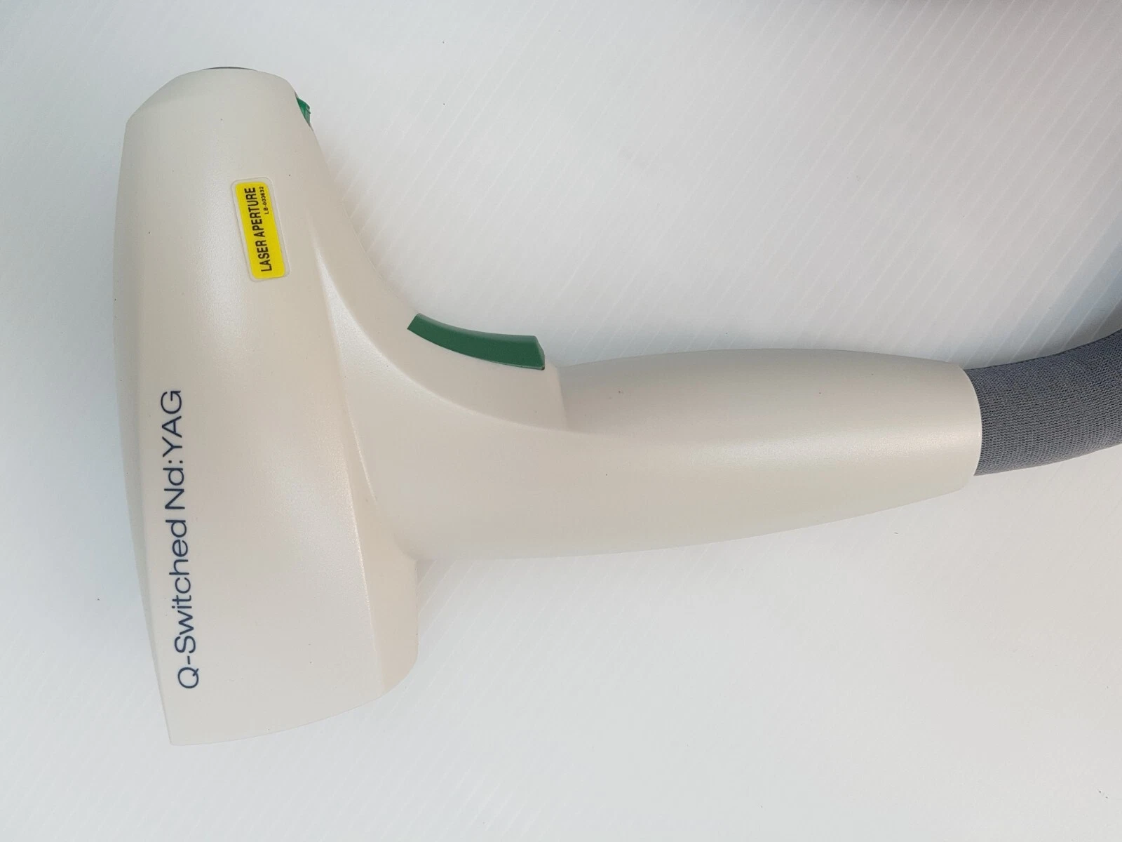 Q-Switched Nd:YAG handpiece side with laser aperture label, Lumenis M22