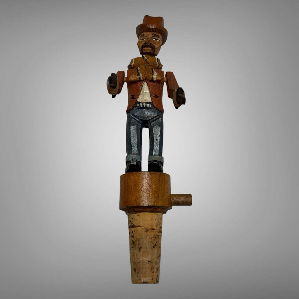 An ANRI hand-carved mechanical wood bottle stopper of a gun-slinging cowboy — Italian folk art meets Wild West in a tiny kinetic masterpiece.