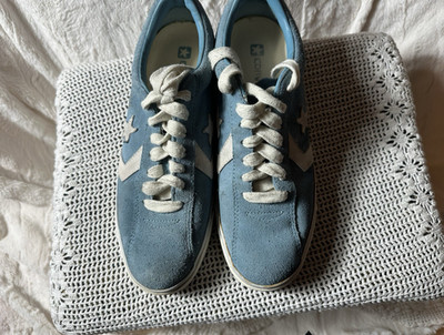 This is a pair of Converse All Star blue leather logo lace up sneakers.