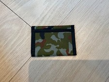 kids wallet for age 8-12. It is green and has multiple pockets inside of it.