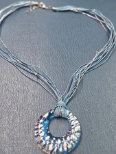 blue lampworked glass donut pendant necklace features silver stardust flecks.