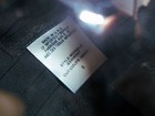 White Guess collection tag on black fabric, size 6, with product details and “MADE IN U.S.A.” text.