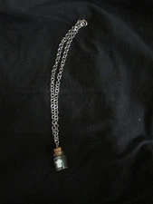 glow in the dark ghost with arms in a bottle necklace