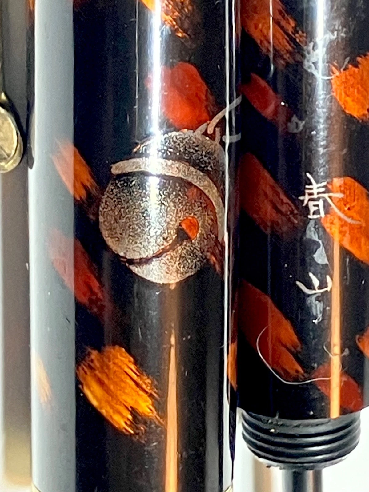 Black vintage fountain pen with orange and brown ink shut off, gold kokeshi emblem, and “HARUYAMA made” text on side.