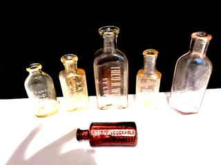 Lot of 8 small vintage glass bottles w/embossed Pharmacy or Medicine names