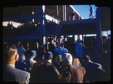 Red Boarder Gathering at Construction Site with Audience and Speakers