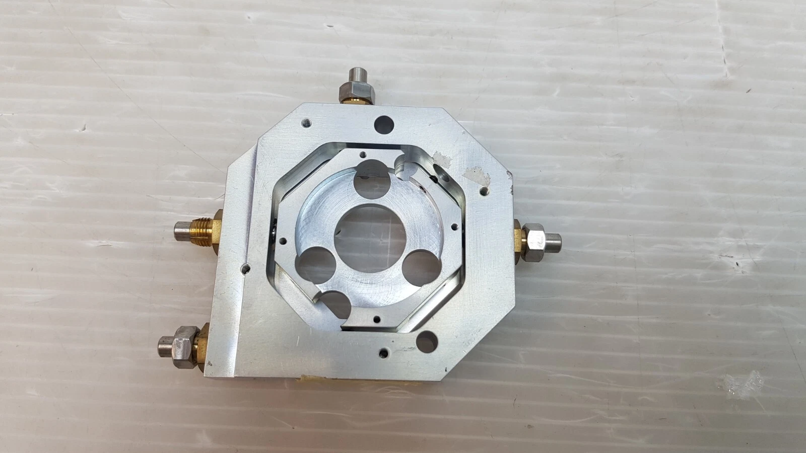 Back of the TA-1073330 aluminum mount with central bore and four adjustment screws