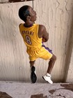 2003 Hallmark Hoop Stars ornament of Kobe Bryant in yellow Lakers jersey, purple side panels, holding basketball.