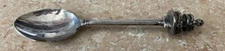 ORNATE DEMITASSE/MINIATURE SPOON WTH SMALL CROWN LIKE DECORATION ON THE TOP-USED