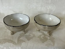 (2) GERMANY BEIGE THREE FOOTED CHINA SCALLOPED TOP OPEN SALT CELLAR w/BLACK RIM