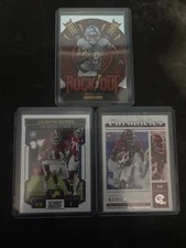 Jahmyr Gibbs Lot. 2023 Score RC, 2023 Chronicles RC, And 2024 Rock Out