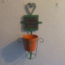 Una nuova ardesia incisa 4" con NIPOTE XXX su e portavaso da parete in metallo verde.