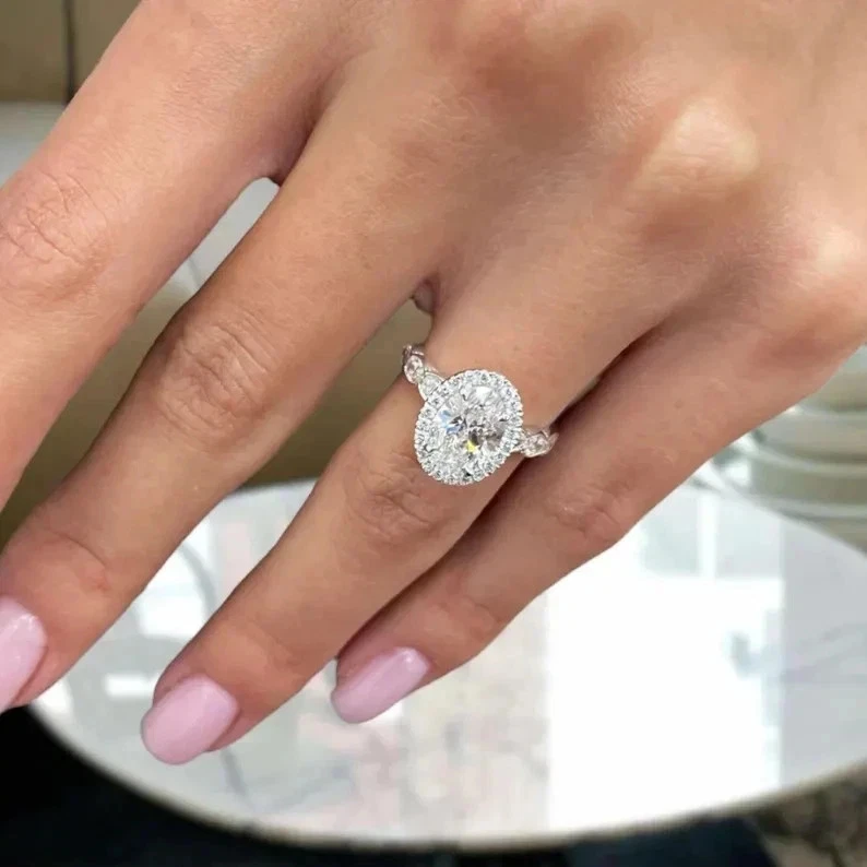 Anillo de compromiso con halo de moissanita de corte ovalado de 4,40 quilates acabado en oro blanco de 14 k Foto 4 de 4