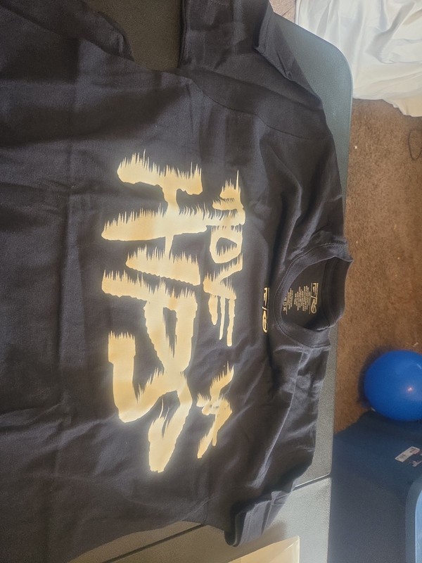 This is a black t-shirt with a stylized gold graphic on the front