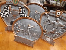 Round and Oval Trophies, new and in the box. 30 assorted sports