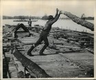 1949 Press Photo Men wield huge logs with tapered ends as rudders in Wisconsin — photo 1