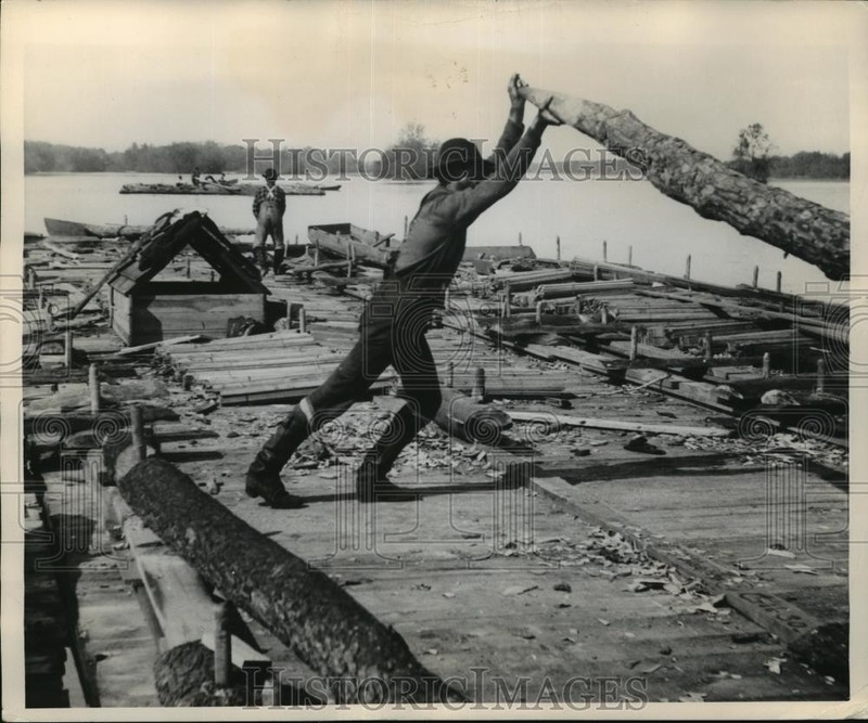1949 Press Photo Men wield huge logs with tapered ends as rudders in Wisconsin