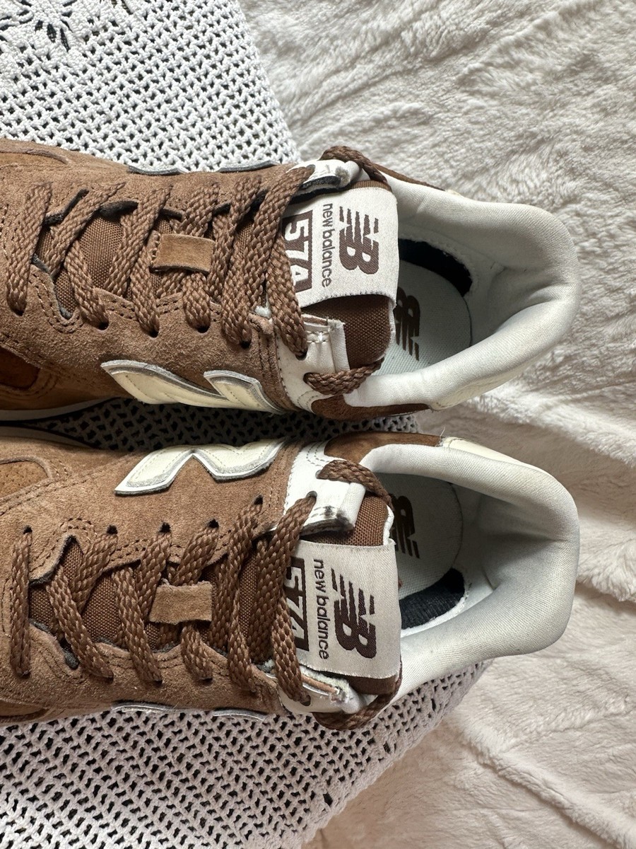 This is a pair of New Balance 574 suede sneakers true brown