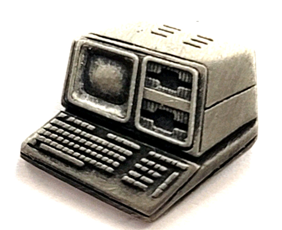 A pewter enamel lapel pin of a chunky retro computer terminal — tiny, nerdy, and instantly recognizable to anyone who grew up with beige-box computing.