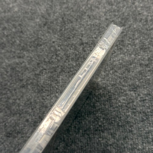 PS3 Sonic's Ultimate Genesis Collection case with clear plastic spine, sealed in protective sleeve on gray surface.