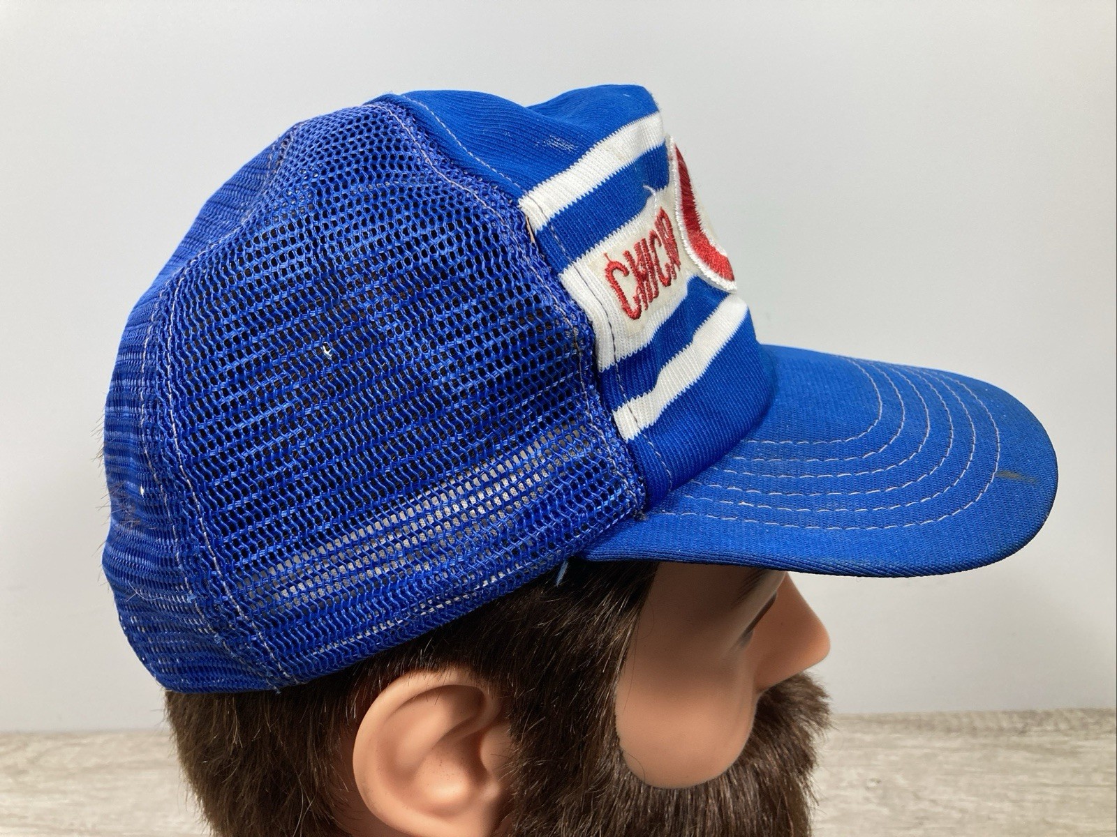 Blue snapback trucker hat with white and red stripe bands and embroidered “Cubs” logo on the front panel.
