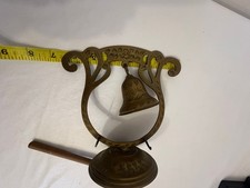 Vintage brass hanging gong / dinner bell features an ornate, floral-etched archw