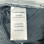 White fabric tag on waistband of blue skinny crop jeans with “ETIENNE MARCEL LOS ANGELES” text and product details.