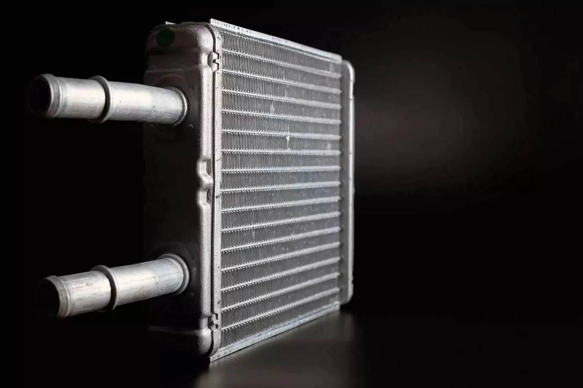 A heater core propped on its side against a black background.